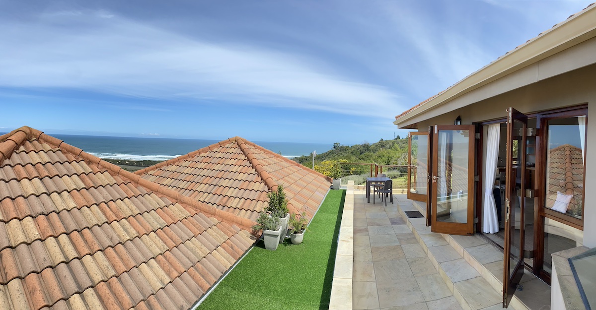Paved stoep sitting above the tiled roofs, the sea on the horizon