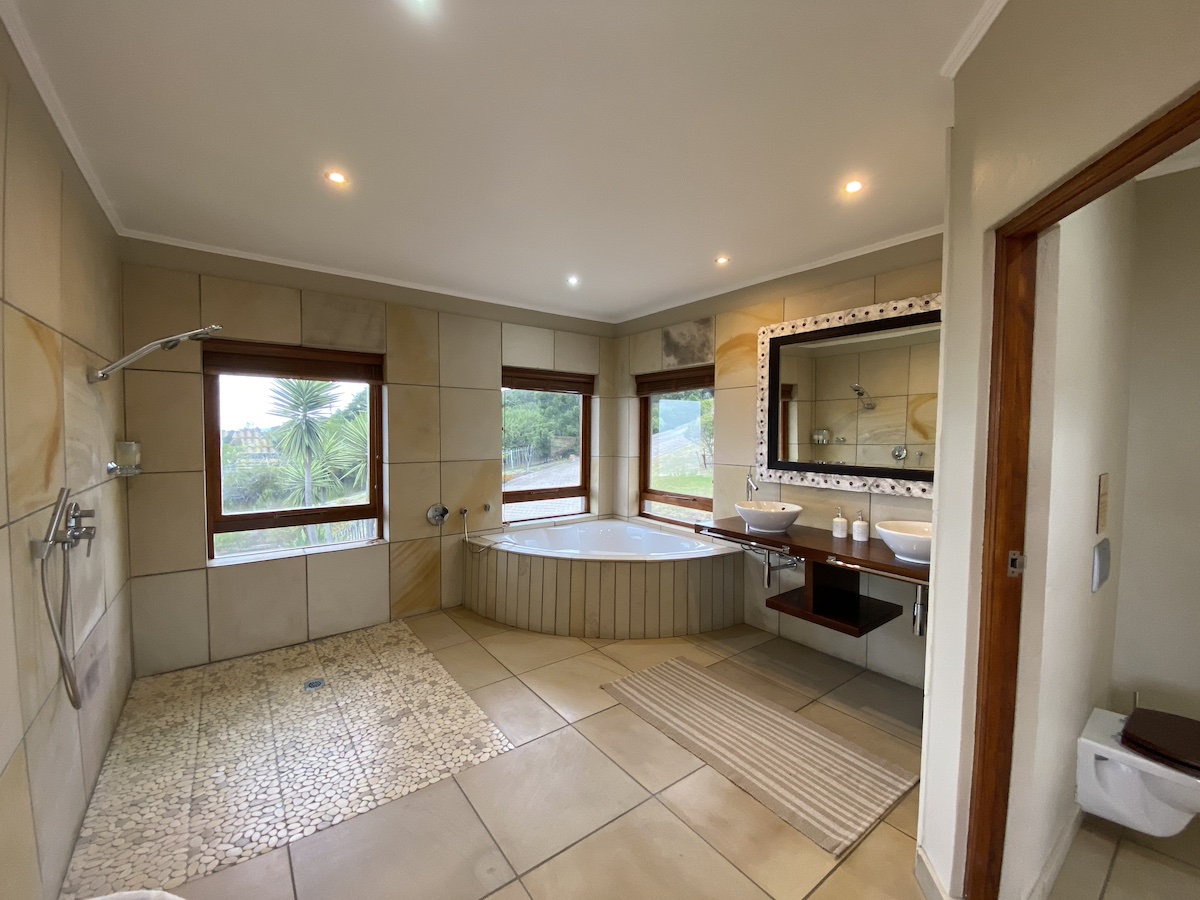 Corner bath under the windows beside a walk-in shower