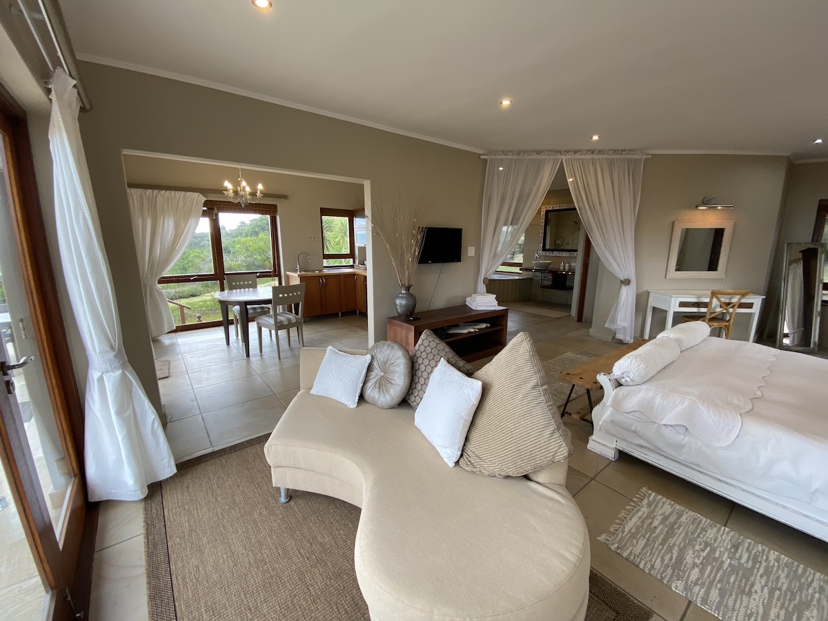 The bedroom opening onto its sitting area and garden view