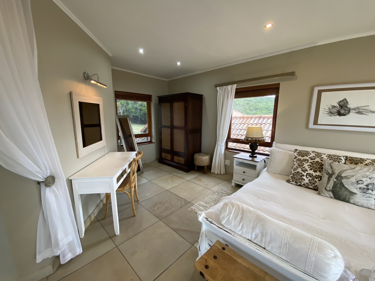 Cream bedroom with a writing desk, wardrobe and garden window