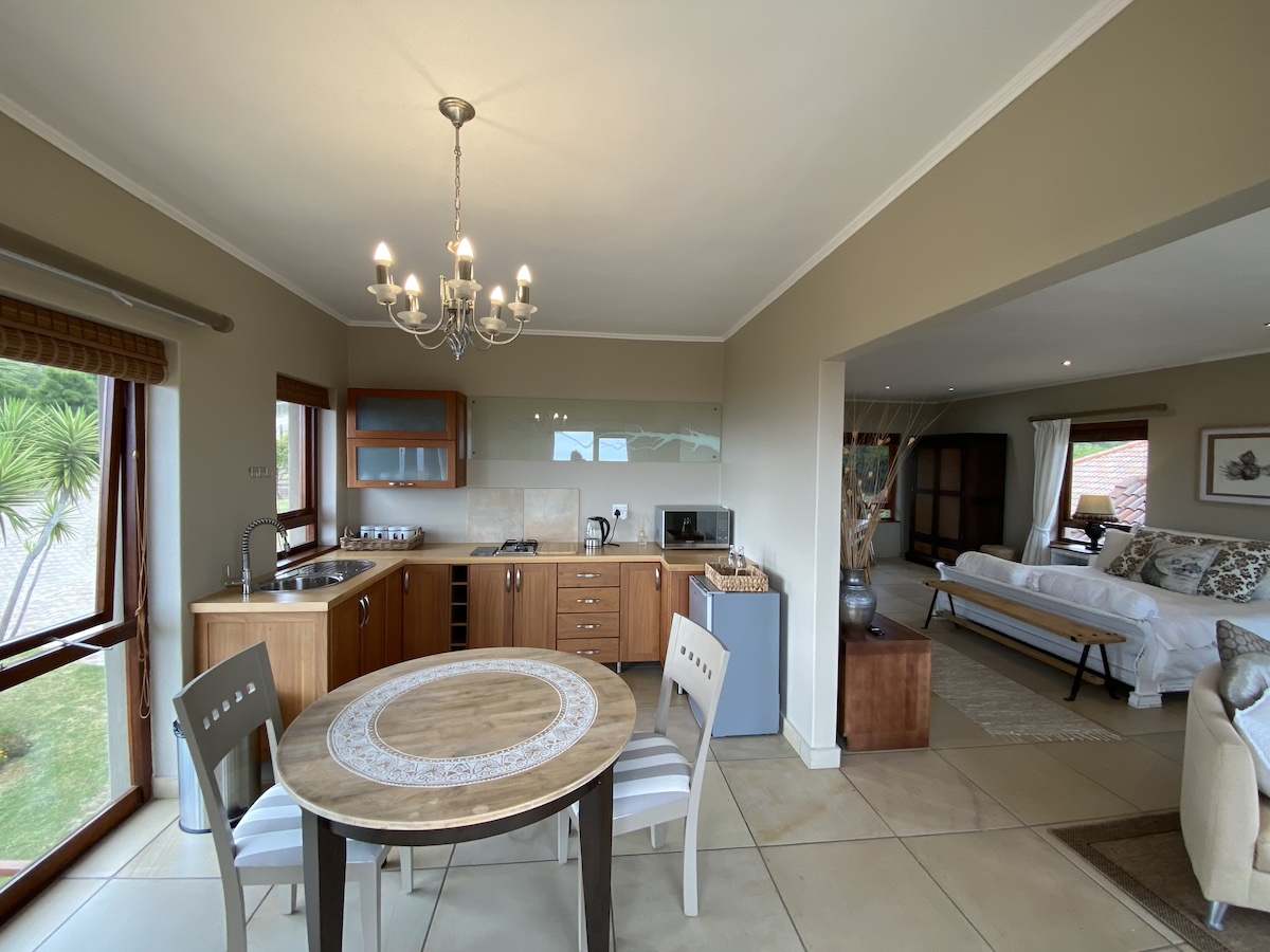 Round dining table with the timber kitchenette behind