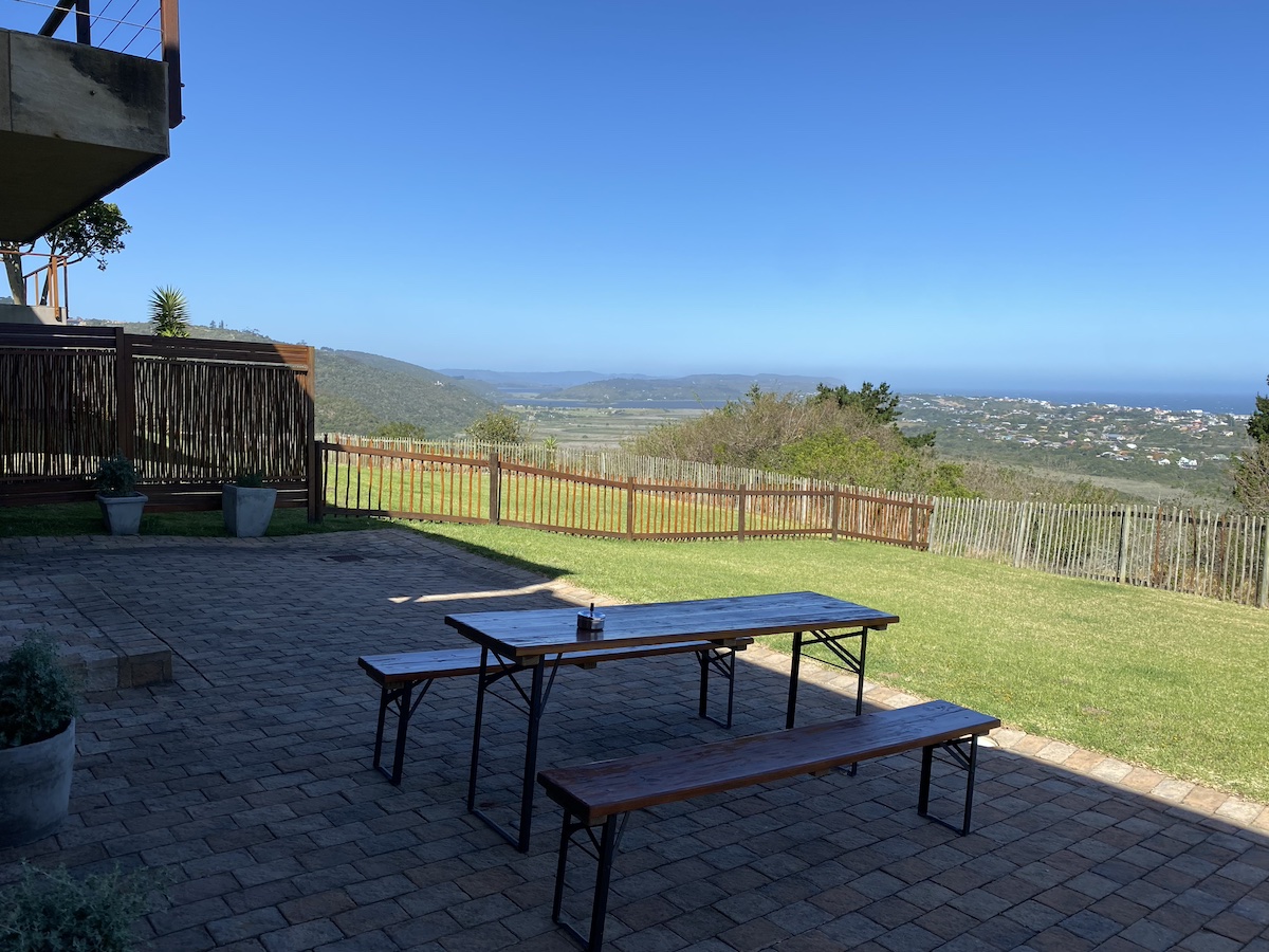 Trestle table and benches on the upper terrace, valley view beyond
