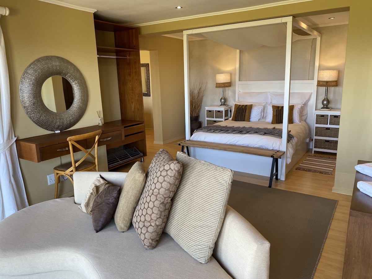 Curved sofa facing the four-poster and dressing table