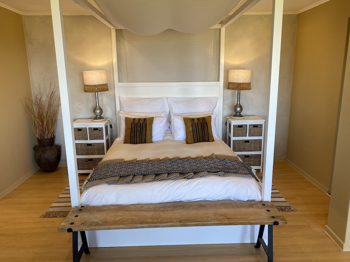 The four-poster bed straight on, flanked by bedside lamps
