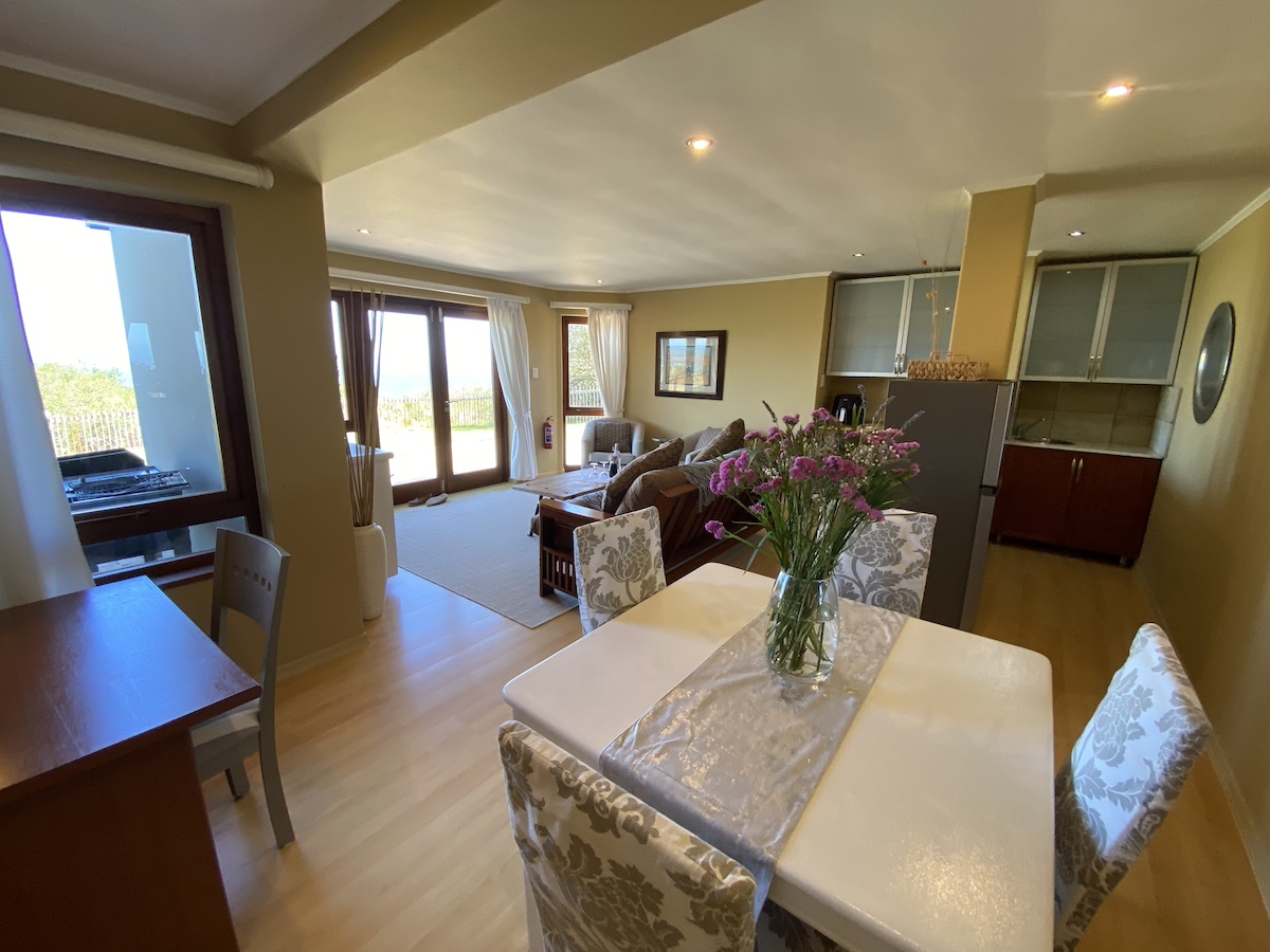 Dining table with fresh flowers, lounge and view beyond